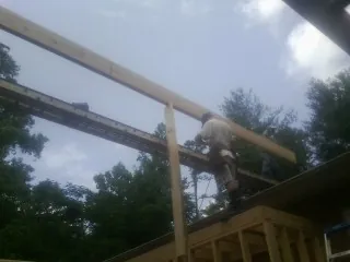 Carpenter setting a ridge beam over a new addition frame — Ice Dam Removal by Roofing Brothers in Olmsted Falls