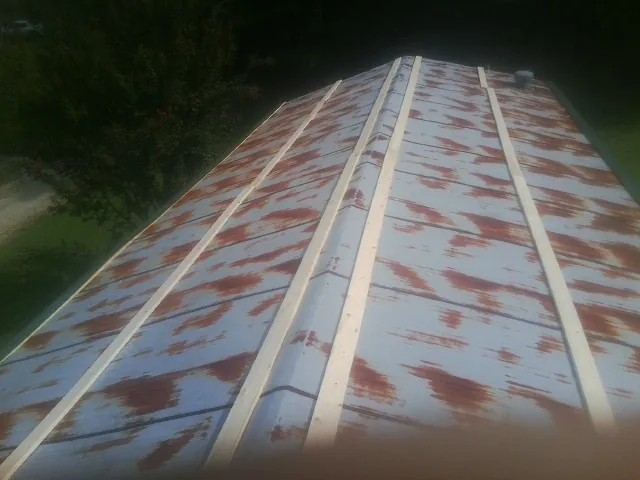 Rusted metal roof panels with new wood purlins before replacement — Storm Damage Roof Repair in Olmsted Falls by Roofing Brothers