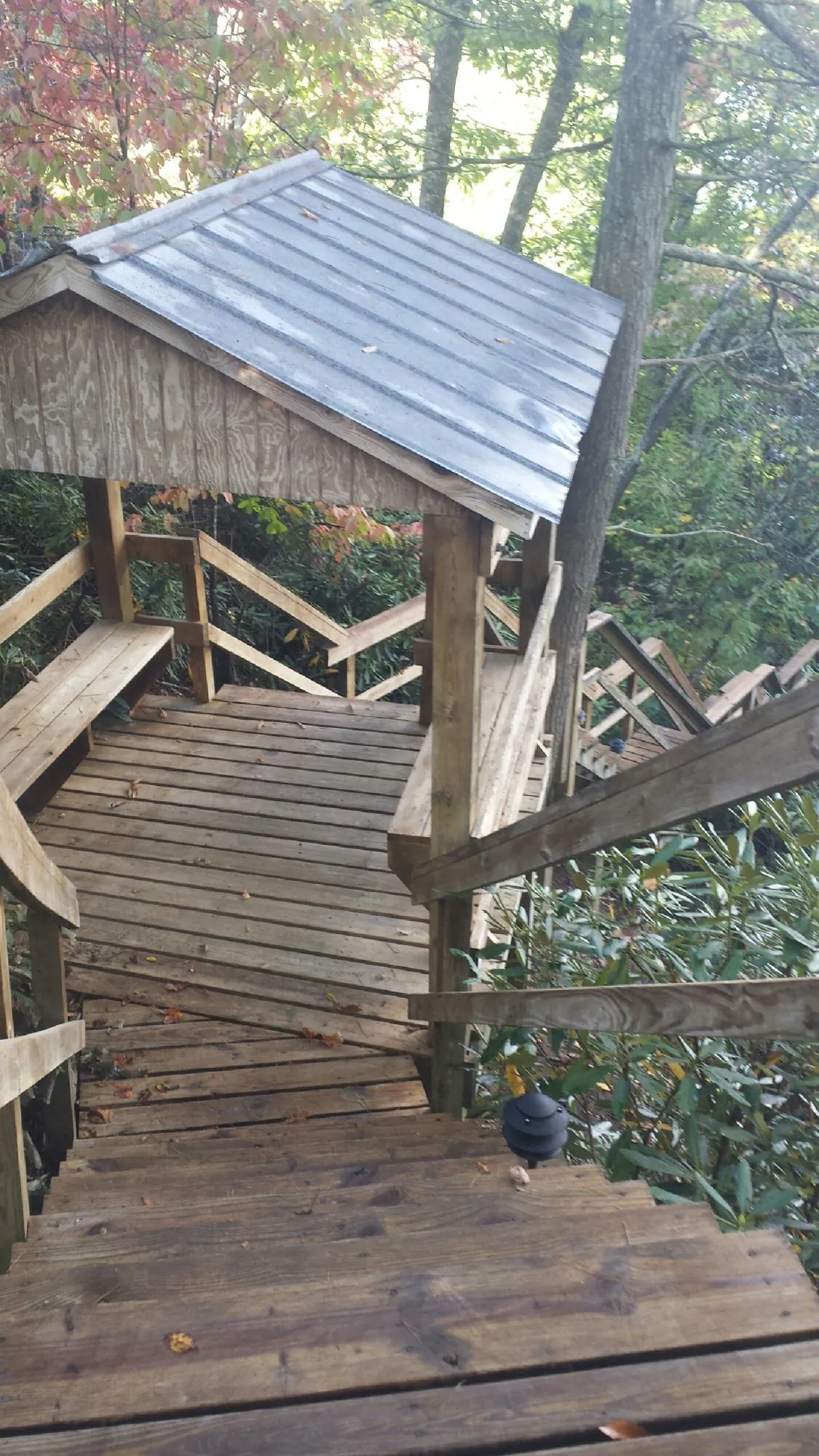 Metal roofed shelter over wooden steps on a wooded walkway — Skylight Repair & Installation work by our crew in Olmsted Falls