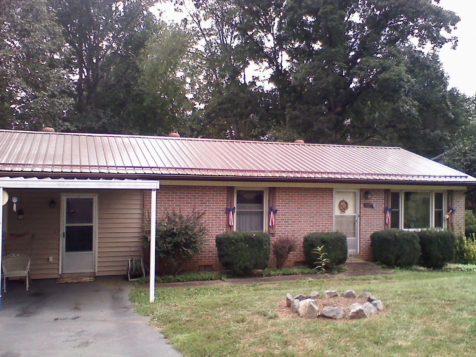 Bronze metal roof and carport on a brick ranch home — Roof Repair work by our crew in Olmsted Falls